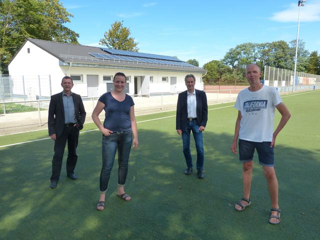 Von links: Jürgen Dietz, Daniela Stürmann, Dr. Ralf Krumpholz und Thomas Büssen vor dem neuen Umkleidegebäude. Vier Mannschaften können sich in den Räumlichkeiten jetzt gleichzeitig umziehen.