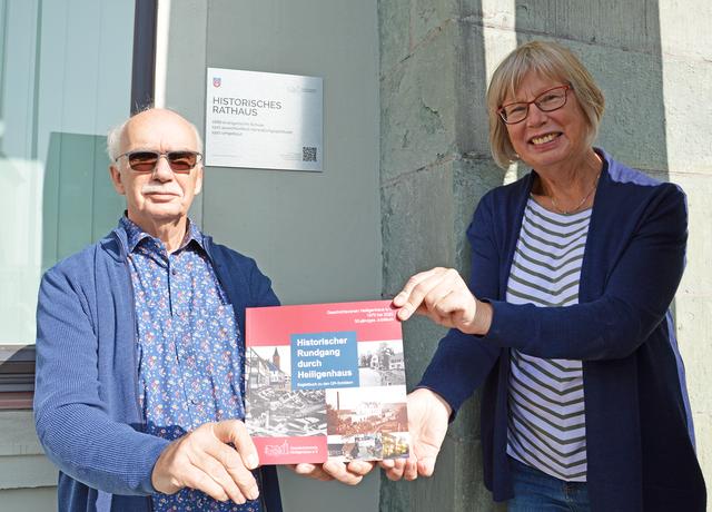 Detlef Gerull und Monika Voß vom Heiligenhauser Geschichtsverein vor der neuen Plakette mit QR-Code am Heiligenhauser Rathaus. In ihrem Buch „Historischer Rundgang durch Heiligenhaus“ sind Informationen über historisch bedeutende Orte der Stadt zusammengetragen.