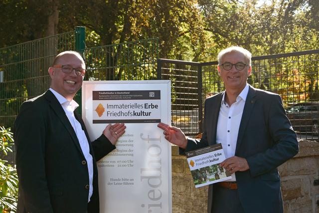 Der Hemeraner Bürgermeister Michael Heilmann (r.) und Friedhofsverwalter Markus Falk vor der neuen Beschilderung am Waldfriedhof.