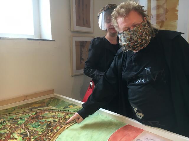 HA SCHULT mit Ehefrau Anna zeigt seinen Wohnsitz im historischen Bereich der Stadt Köln - am Köln-Stadtmodell des Künstlers Theo Giesen, das aktuell in der RUHR GALLERY MÜLHEIM zu sehen ist.