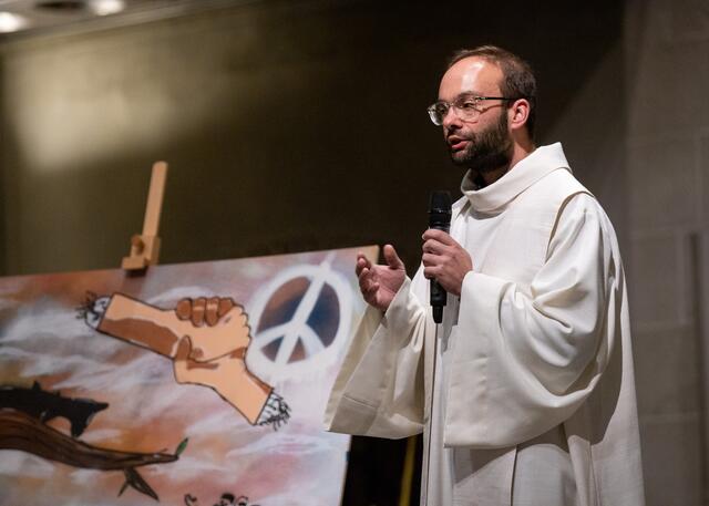 Kaplan Maximilian Strozyk vor einem der gesprayten Bilder der Schülerinnen und Schüler aus dem Bischöflichen Schulzentrum Am Stoppenberg. | Foto: Kirchenkreis Essen/Achim Pohl