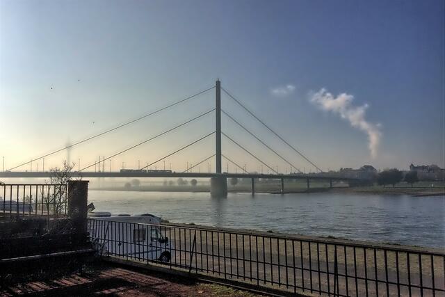 Leicht dunstig ist der Rheinturm: Blick vom Rheingärtchen Richtung Oberkasseler Brücke