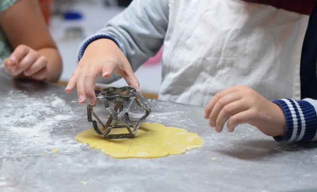 Kinder haben viel Spaß am gemeinsamen Backen. Nur mit dem Naschen des Teiges sollte man vorsichtig sein.