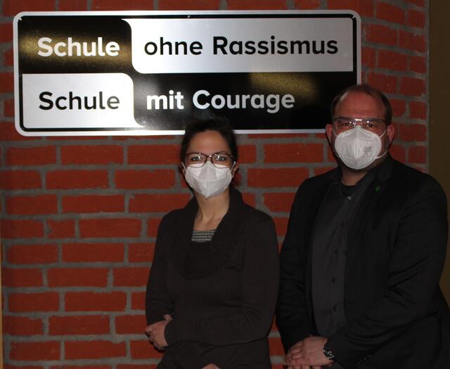 Schulleiter Markus Westhoff und stellvertretende Schulleiterin Dr. Vera Merge mit dem Schild „Schule ohne Rassismus – Schule mit Courage“, das nun offiziell im Gymnasium Petrinum hängen darf.