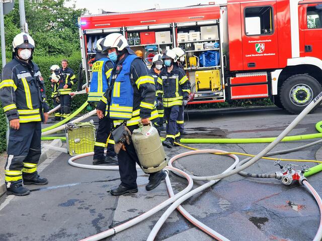 Hier wird eine Gasflasche ins Freie transportiert und gesichert.