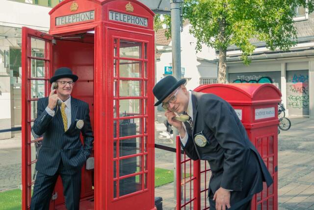 Mit aktueller Telefon Technologie verortet das Kölner Urban Art Ensemble „Die Servicepioniere“ in Kooperation mit „foolpool“ diese Installation in zwei alten englischen Telefonzellen, die mitten in Velbert bzw. Mettmann aufgebaut werden.