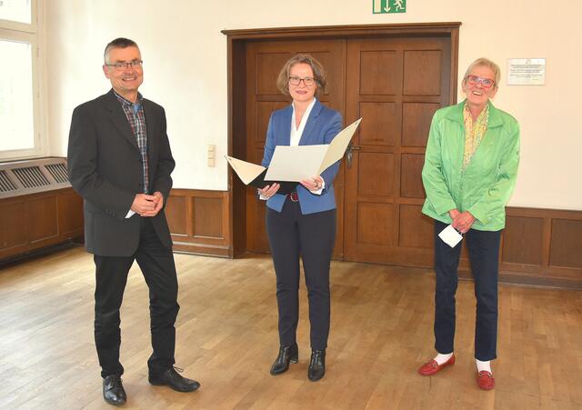 Pfarrer Gisbert Biermann und Annemarie Schlautmann (r.) bekamen den Förderbescheid von Ministerin Ina Scharrenbach überreicht. Foto: peb