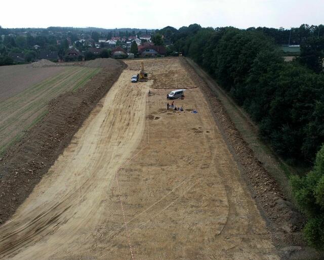 Drohnenfoto der Fundfläche im Norden von Frömern (Hintergrund) unmittelbar neben der Eisenbahnstrecke (rechts). Foto: LWL-Archäologie/D. Riemenschneider