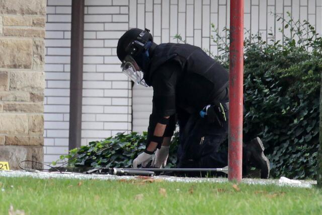 Ein Polizist in Schutzkleidung sucht nach der Explosion in der Sparkasse nach weiteren Gefahren. | Foto: Magalski