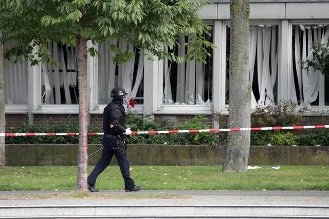 Ein Polizist in Schutzkleidung sucht nach der Explosion in der Sparkasse nach weiteren Gefahren. | Foto: Magalski