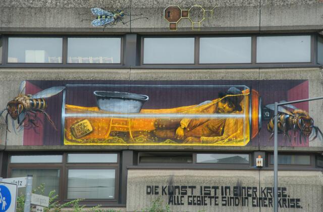 Fertig ...
Entspannt ruht Beuys in der durchsichtigen Spraydose. Die bekannte Babywanne schwimmt auf den gold gelben Honig und der Fernseher versinkt im süßen Nektar. Ob das wohl Einfluss auf die Botschaft von hat?
Ganz oben sieht man eine Schlüssellochwabe von Fabio Fedele. Ob das Überleben der Insekten der Schlüssel zum Überleben der Menschheit ist?

Complete ...
Beuys rests relaxed in the transparent spray can. The well-known baby bath floats on the golden yellow honey and the television sinks in the sweet nectar. Does that have any influence on the message of?
At the top you can see a keyhole honeycomb by Fabio Fedele. Is insect survival the key to human survival? | Foto: Samara Blue Urbex Art