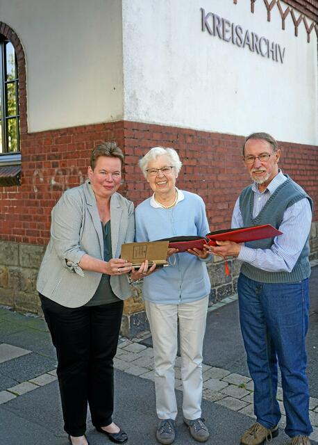 Elisabeth Schmitz zeigt Kreis- und Stadtarchivarin Stephanie Pätzold und Prof. Dr. Gerhard Sollbach eines der reich bebilderten Fotoalben.