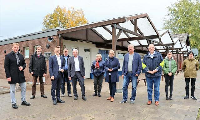 Freuen sich über den Zuwendungsbescheid zur Modernisierung des Umkleidegebäudes: Bürgermeister Dirk Haarmann (3. v. l.), Paul Jakobs (5. v. l.) und Klaus Kuckhoff (4. v. r.), Vorstandsmitglieder des SV Spellen, Landtagsabgeordnete Charlotte Quik (5. v. r.), Beigeordneter Jörg Rütten (3. v. r.), Marc Indefrey (l.), Vorsitzender des Stadtsportverbands Voerde sowie Vertreterinnen und Vertreter der Fraktionen des Stadtrats.