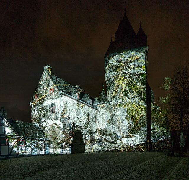 Beim Probeleuchten setzten die Profis des Künstlerkollektivs um den Lüdenscheider Lichtkünstler Tom Groll den Pulverturm im Burginnenhof per Architekturprojektion in Szene. Foto: Stephan Sensen/Märkischer Kreis