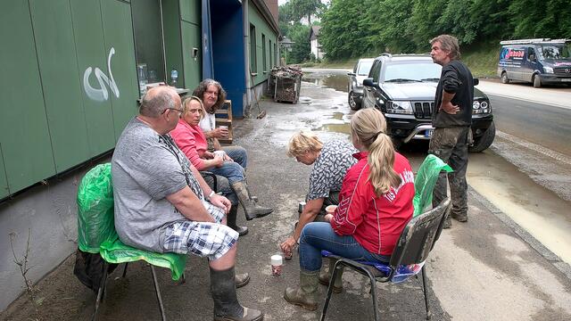 Hagen-Dahl: Anwohner sitzen in Gummistiefeln auf Stühlen an der B54. Archiv-Foto: Ulrich Rabenort