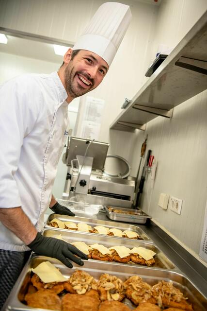Wenn das Kochen Spaß macht, kann es später nur gut schmecken: Koch Manuel Döhla kümmert sich um die Zwiebelschnitzel.
 | Foto: Foto: LWL/Paul Metzdorf