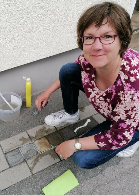 Katrin Rieckermann vom "Arbeitskreis Lüner Stolpersteine" reinigt die Stolpersteine der Familie Rose.  | Foto: Katrin Rieckermann