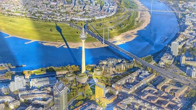 Foto in der Wandelhalle: Blick auf den Landtag unmittelbar neben der Kniebrücke. Auf der anderen Rheinseite liegt  Oberkassel. Rund um den Rheinturm sind die vier geplanten kreisrunden Erweiterungsbauten des Landtags zu erkennen.  | Foto: ©Margot Klütsch