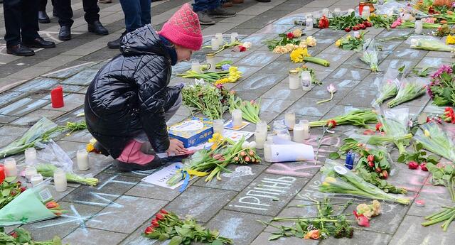 Ukrainisches Mädchen legt Blumen für Verstorbene nieder | Foto: Horst Nauen
