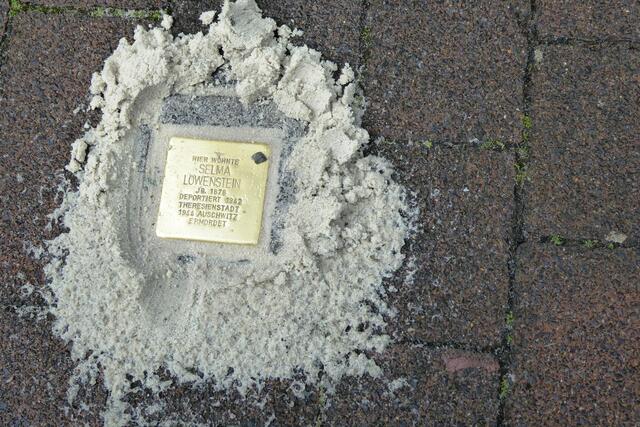 Der freigelegte Stolperstein, auf den Hannah Mills gemäß jüdischer Tradition einen Stein des Gedenkens gelegt hat.