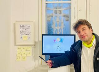 Jedes der 100 Unikate wird um 1 EURO verteuert angeboten, aktuell war am Ende der Vernissage das Exemplar "INFLATION 30" für 30 EURO zu erwerben. Auf dem Foto der Künstler Jan Arlt vor dem Video, das die 100 individuellen Kunstwerke präsentiert (die Nr. 100 kostet demnach 100 EUR) - schnell sein lohnt sich! | Foto: Mülheimer Kunstverein und Kunstförderverein KKRR