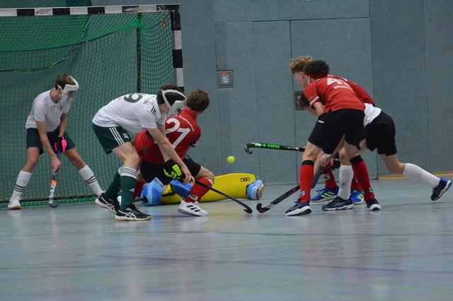 Großchance für den HTC (rote Trikots) im Spiel gegen Ratingen. Marlon Wenkser (Nummer 21) beim Strafeckennachschuss, aufmerksam beobachtet von Jannik Waterkamp und Raphael Georg. Der Ball geht knapp am Tor vorbei.  | Foto: Carsten Ackermann