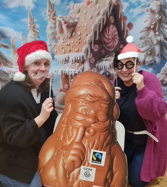 Der Riesen-Papp-Nikolaus der Umweltberaterin wandert aktuell von Ort zu Ort,  - hier zur Fotoaktion in der VHS, zum Heerener Adventskalender. Ophelie Lespagnol und Jutta Eickelpasch nehmen ihn in ihre Mitte.