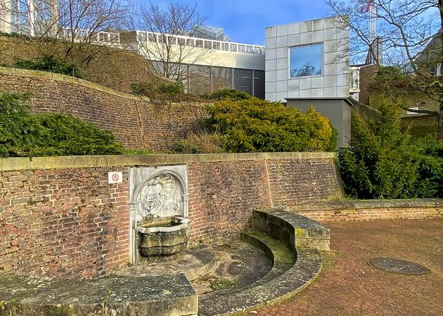 Die "Reisterrassen" (1974-82) von Hans Hollein bilden den oberen Teil des Abteigartens. Hier integrierte Hollein ein altes Brunnenbecken mit Faunmaske in ein neugestaltetes  Wasserbecken. Im quadratischen Fenster der Cafeteria spiegelt sich die Natur.  | Foto: ©Margot Klütsch