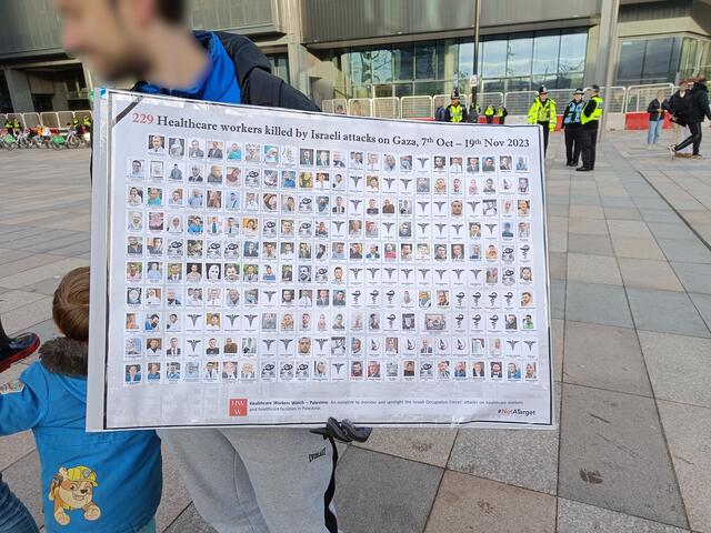 Plakat mit 229 Menschen aus dem Gesundheitswesen, die  im Jahr 2023 durch israelische Angriffe auf Gaza ermordet wurden. Bis jetzt wurden über 50.000 Menschen im Gazastreifen getötet. Die meisten davon Zivilisten. Darunter tausende Kinder. | Foto: By OwenBlacker - Own work, CC0, https://commons.wikimedia.org/w/index.php?curid=143513330