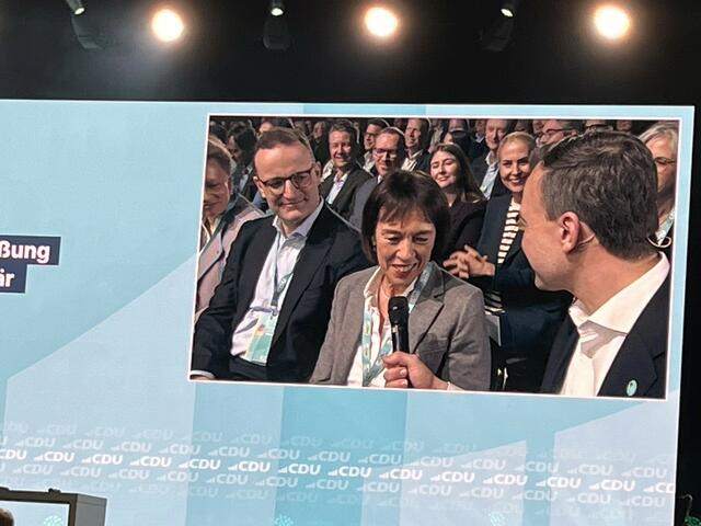 Paul Ziemiak setzte sich zu Charlotte Merz, Gattin von Friedrich Merz, in die erste Reihe, die sich freute, heute ihren Mann nicht nur auf Instagram oder im Fernsehen, sondern live auf der Bühne zu sehen. Links zu sehen Jens Spahn. | Foto: Andrea Becker