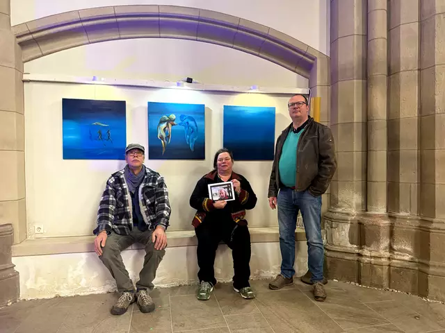 Das Foto zeigt Marayle Küpper, Arno Bortz und Pfarrer Martin Winterberg (rechts im Bild, stehend) beim Aufbau der Ausstellung in der Salvatorkirche vor den Werken von Wilfried Weiß.
Foto: salvatorkirche.de
