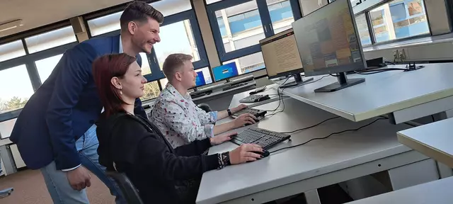 Wirtschaftslehrer Tobias Nagels schaut, was Jade (17) und Florian (20) erarbeitet haben.  | Foto: Dabitsch