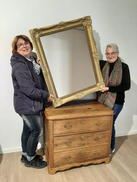 Sabine Hildebrand (li.) und Veronika Czerwinski präsentieren die ersten Vintage-Möbel, die in die neue Bibliothek einziehen werden. Foto: Stadt Menden