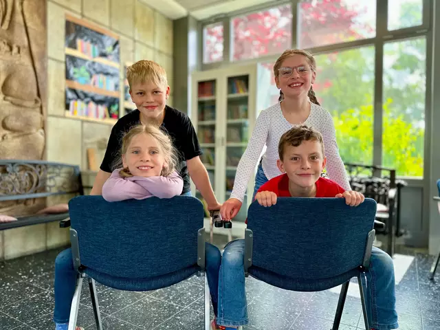 Paul und Romy (oben), Lilly und Nils (Sitzend) freuen sich über die aufbereiteten Stühle.