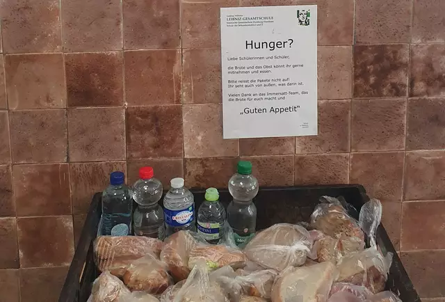 Im Schulflur macht ein Info-Plakat auf die Angebote aufmerksam – inklusive kontaktloser Versorgung mit Wasser, Obst und Broten. | Foto: Thomas Facklam