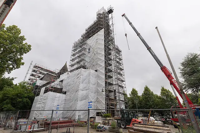 Der massive Autokran vor der eingerüsteten Kirche. | Foto: Achim Pohl | Bistum Essen