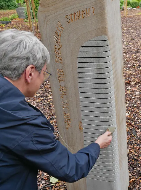 Pfarrerin Susanne Gutjahr-Maurer bringt die Gedenkstele zum Klingen. | Foto: Kirchenkreis Essen/Stefan Koppelmann