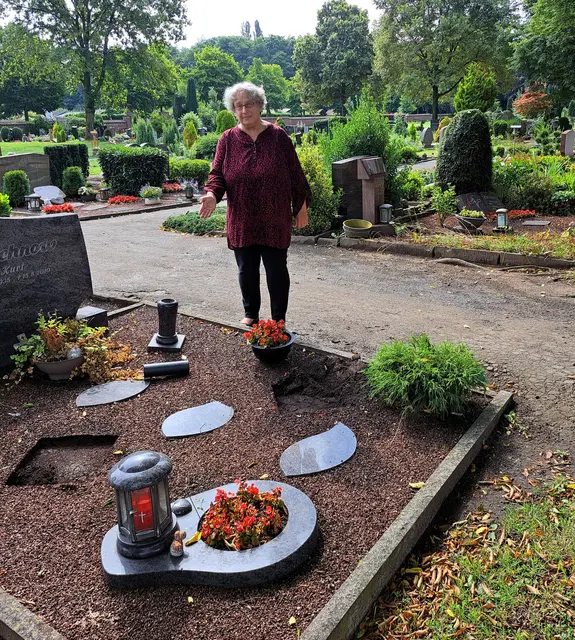 Fassungslos steht Pfarrerin Anja Humbert vor einem Grab, auf dem sich für die Diebe offensichtlich wertvolle und verwertbare Gegenstände befanden.
Foto: www.bonhoeffer-gemeinde.org
