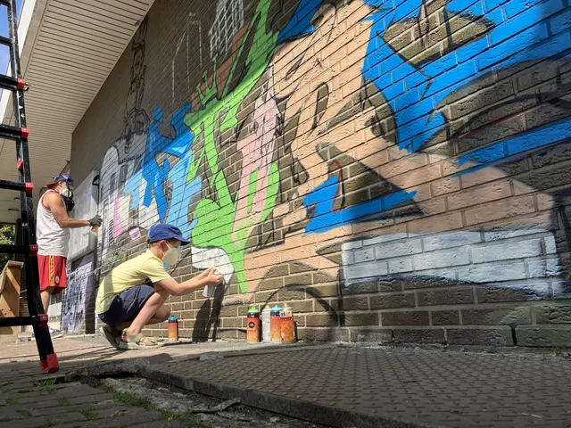 Kreative Köpfe am Werk: Graffiti-Künstler Özgür Güzel (links) gestaltete gemeinsam mit Kindern und Jugendlichen die Fassade des Begegnungshauses in Köln-Roggendorf mit einer Stadtkulisse auf der einen und einer Naturlandschaft auf der anderen Seite. | Foto: Vonovia