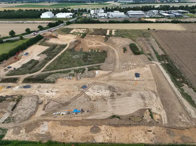 Luftbild der Grabungsfläche, Blick nach Norden. Oben ist die B1 und der Flughafen Dortmund zu erkennen. Unten im Bild sind die Pfostengrundrisse der jungsteinzeitlichen Häuser zu erkennen.
Foto: LQ Archäologie/C. Bariszlovich