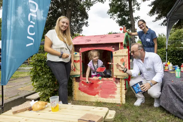 Kinder aus dem Quartier bemalten mit großer Begeisterung das von Vonovia gespendete Gartenhäuschen beim Stadtteilfest in Waltrop. Mit dabei: Laura Lehnert (links) und Melanie Hansen (hinten) von der Diakonie Waltrop und Vonovia Quartiersmanager Karl Cielontko (rechts). | Foto: Vonovia / Kreklau