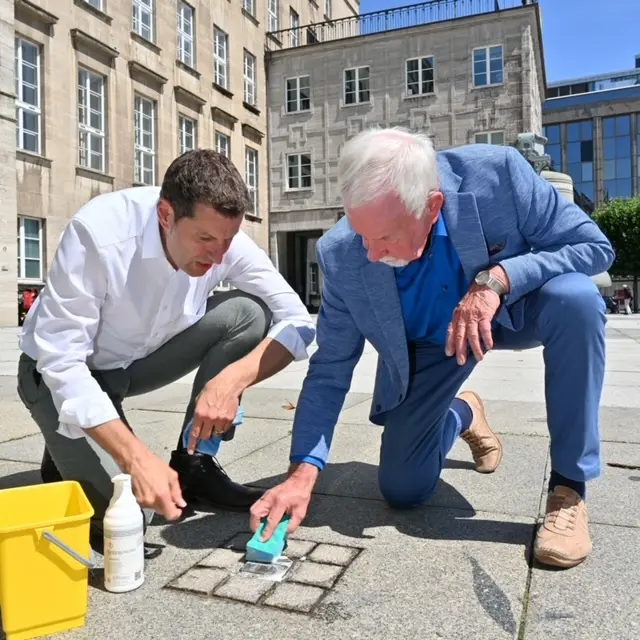 Thomas Eiskirch und Ernst-Otto Stüber reinigen den Stolperstein für Dr. Otto Ruer 
Oberbürgermeister Thomas Eiskirch und Alt-Oberbürgermeister Ernst-Otto Stüber reinigen am 26. Juli 2023 den Stolperstein für Dr. Otto Ruer vor dem Rathaus in Bochum. | Foto: Stadt Bochum