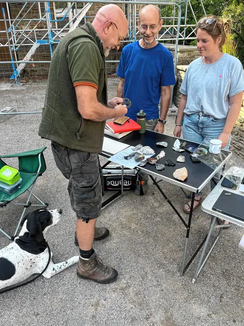 Mirjam Kötter, Leiterin der Unteren Denkmalbehörde und Stadtarchäologie der Stadt Hagen (re.), und Wolfgang Heuschen, Grabungsleiter an der Blätterhöhle in Hagen (2.v.l.), schauen sich den Riemendurchzug mit Pferdedarstellung von Finder Michael Döhner an. 
Foto: Stadt Hagen