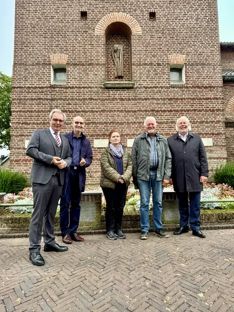 Josef Gietemann, Paul-Josef Heister, Silvia Luggenhölscher, Rainer van Hout und Ferdi Böhmer (v.r.) vor der Kirche von Breedeweg mit Blick auf das Relief „Toter Soldat“. | Foto: Marco Cillessen
