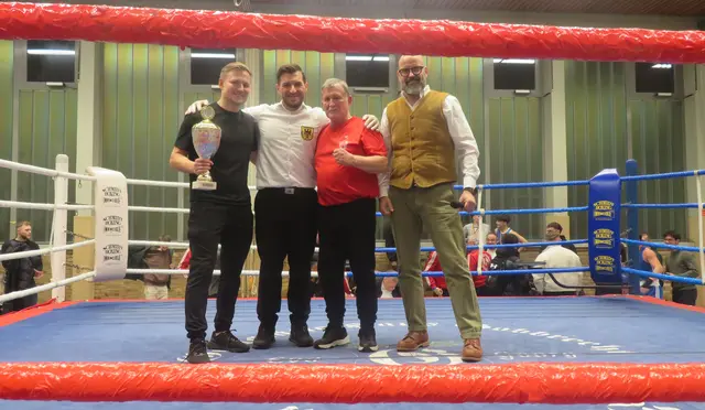 Nach der Überreichung des Pokals stellen sich von links
zum Bild: Co-Trainer Felix Falk, Ringrichter Victor Ares 
Vilarino, Trainer  Erich Weber und Ringsprecher Dirk van
der Pluym. 