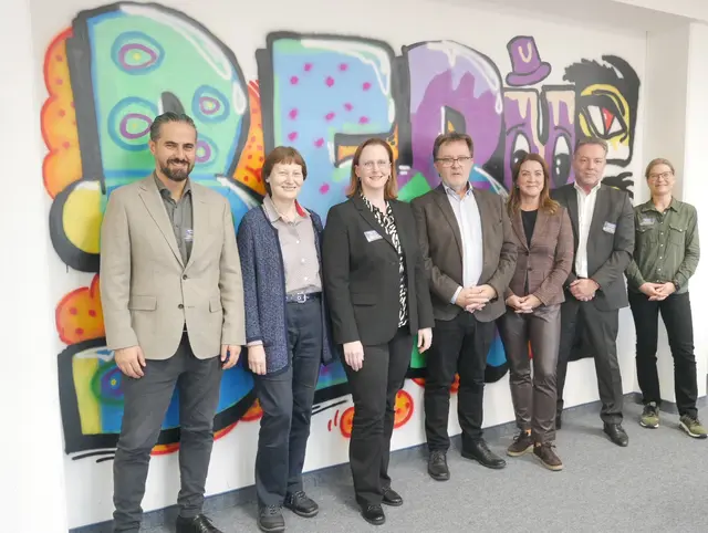 Bildunterschrift: Die Bilanz wurde in diesem Jahr im Berufsinformationszentrum der Arbeitsagentur Oberhausen durchgeführt. Die Ausbildungsmarktpartnerinnen und -partner stehen hier vor dem Graffiti, das Jugendliche im Rahmen des Ausbildungscamps Oberhausen an die Wand gesprayt haben – v. l. n. r: Robert Schweizog, Elisabeth Schulte, Barbara Yeboah, Dieter Hillebrand, Valeska Hurraß, Jürgen Koch, Stephanie Peters  | Foto: Katja Hübner