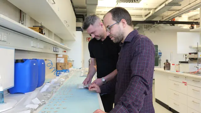 Wilhelm Harms und Jakob Nowak (von links) untersuchen im Labor die Proben der Test-Legierungen für das Aluminium-Rad.  | Foto: FH Dortmund / Vincent Beringhoff