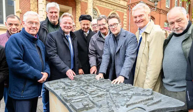 Oberbürgermeister Thorsten Berg (4.v.l.), Initiator des Projektes Dr. Stefan Welbers (5.v.l.) und Künstler Felix Brörken (3.v.r.) eröffneten feierlich das neue Sterkrader Stadtmodell.  | Foto: Stadt Oberhausen/Tom Thöne