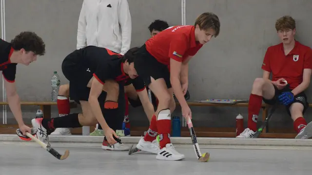 HTC-Akteur Paul Flocke (rotes Trikot) behauptet den Ball gegen zwei Düsseldorfer Gegenspieler. Das Ganze beobachtet von Raphael Georg (rechts auf der Bank).  | Foto: Carsten Ackermann 