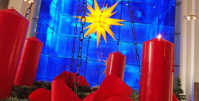 Der Adventskranz in der Marktkirche, mit dem Herrnhuter Stern und dem blau-gläsernen Westchor im Hintergrund. | Foto: Kirchenkreis Essen/Stefan Koppelmann